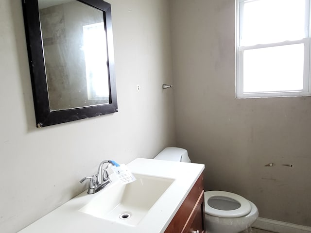 bathroom with vanity, toilet, and a wealth of natural light