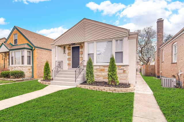 view of front of house with a front yard and central AC unit