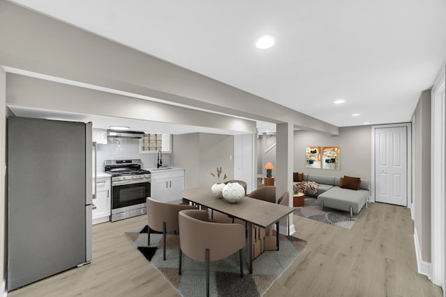 dining space with light hardwood / wood-style flooring and sink