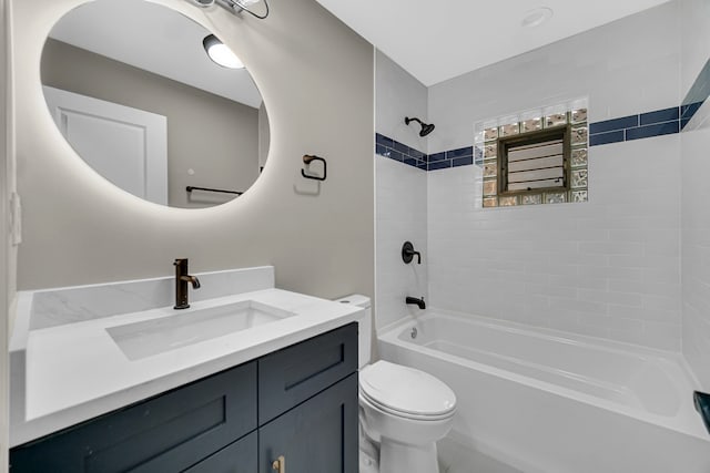 full bathroom featuring vanity, tiled shower / bath combo, and toilet