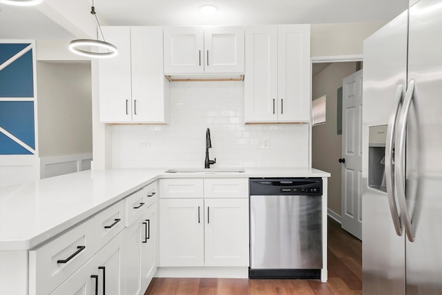 kitchen featuring pendant lighting, white cabinets, sink, and appliances with stainless steel finishes