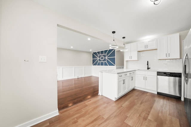 kitchen featuring white cabinets, dishwasher, pendant lighting, and kitchen peninsula