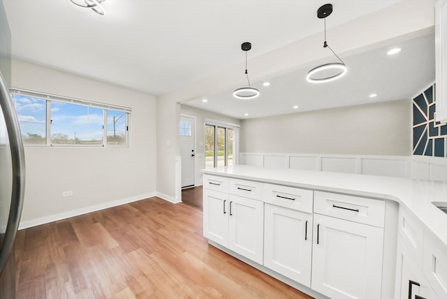 kitchen with white cabinetry, pendant lighting, and light wood-type flooring