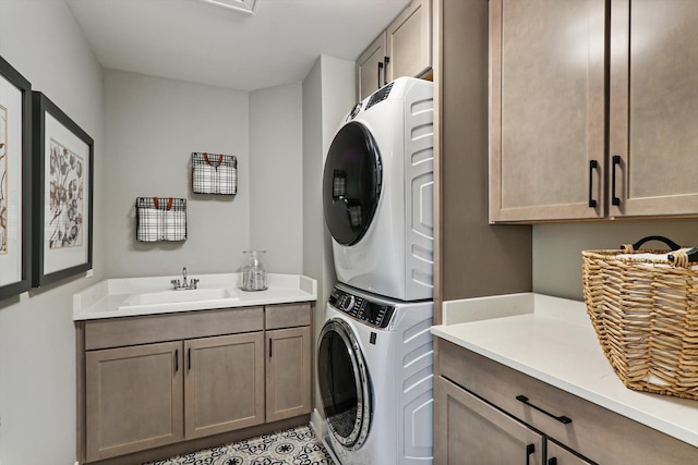 clothes washing area featuring cabinets, stacked washer / dryer, and sink