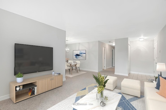 living room featuring light carpet, baseboards, and a chandelier