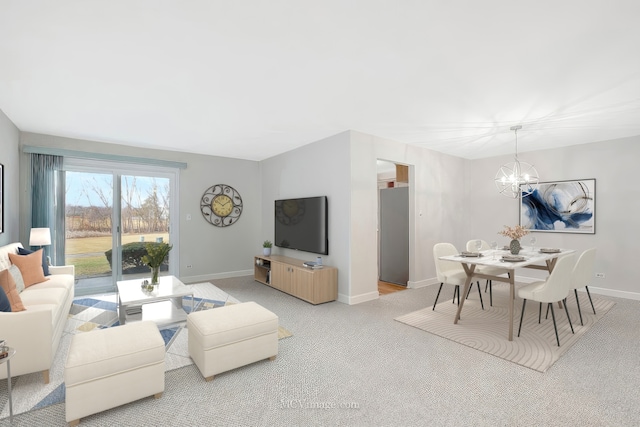 living area featuring light carpet, an inviting chandelier, and baseboards