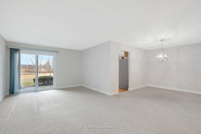 spare room with an inviting chandelier, baseboards, and light colored carpet