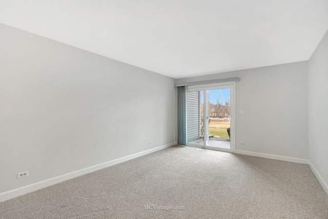 empty room featuring light carpet and baseboards