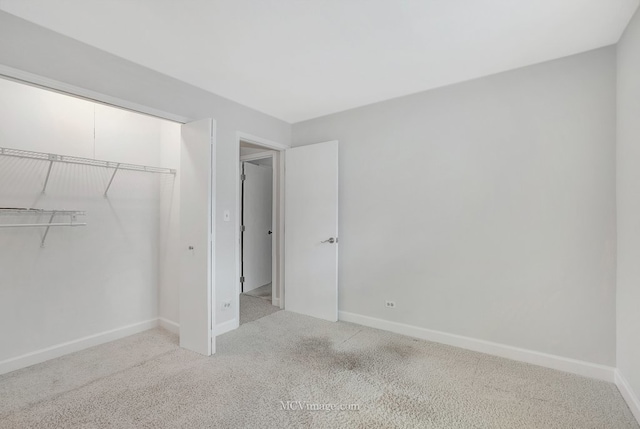 unfurnished bedroom featuring a closet, baseboards, and carpet flooring