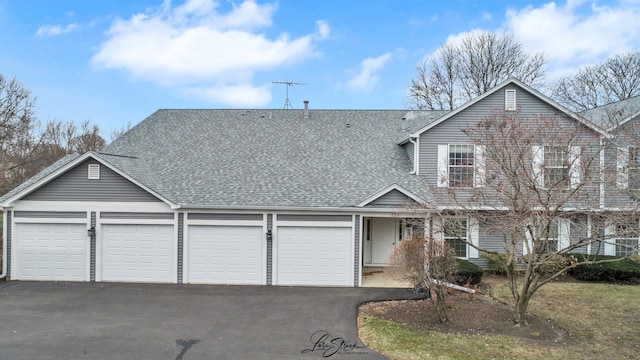 view of front of property featuring a garage, aphalt driveway, and a shingled roof