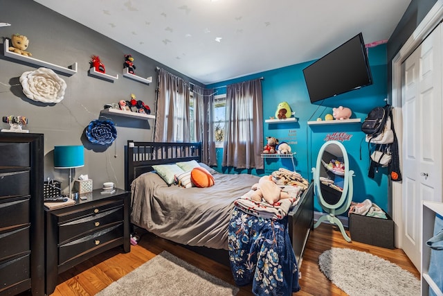 bedroom with hardwood / wood-style floors and a closet