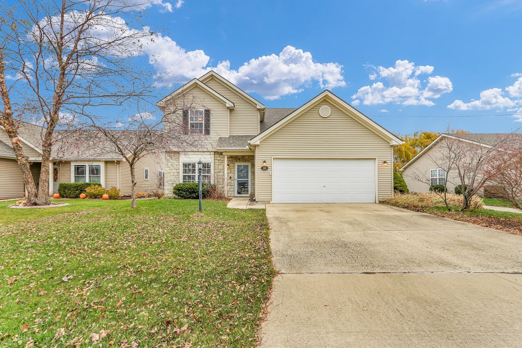 view of property featuring a garage and a front lawn