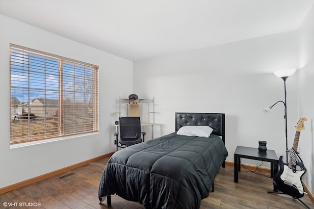 bedroom with hardwood / wood-style flooring and multiple windows