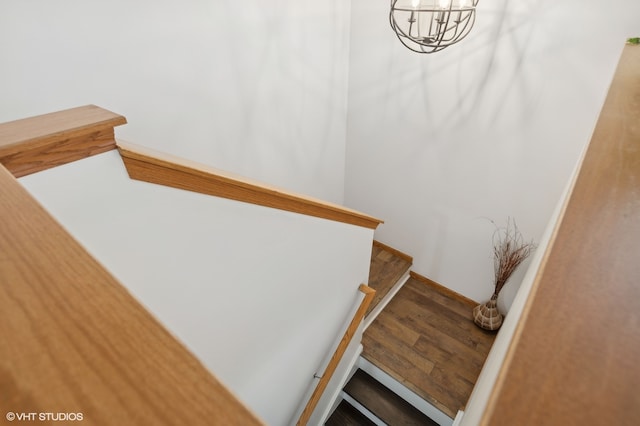 staircase featuring hardwood / wood-style floors and a chandelier