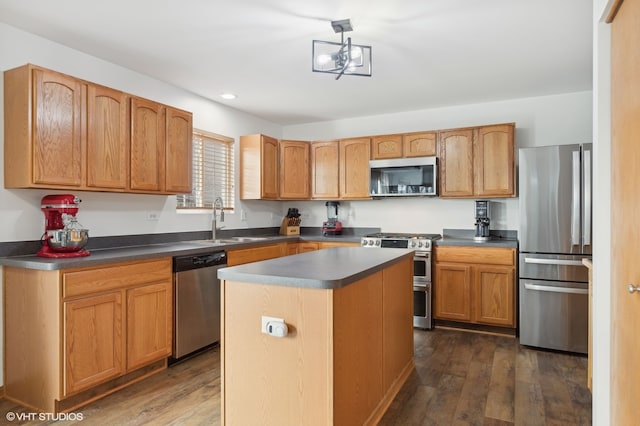 kitchen with sink, dark hardwood / wood-style floors, appliances with stainless steel finishes, a notable chandelier, and a kitchen island