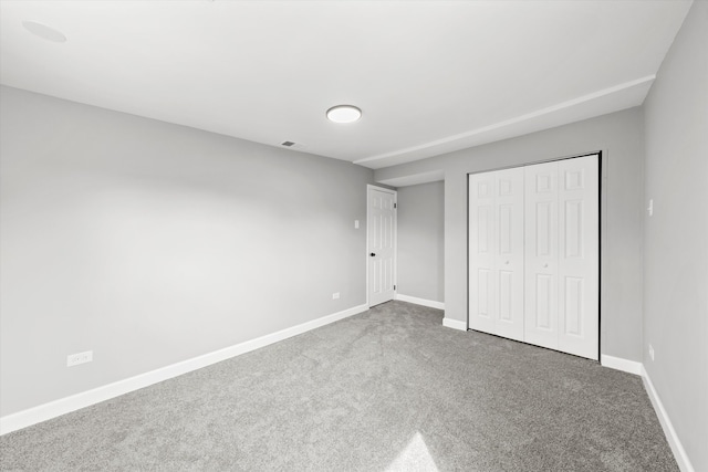 unfurnished bedroom featuring carpet flooring and a closet