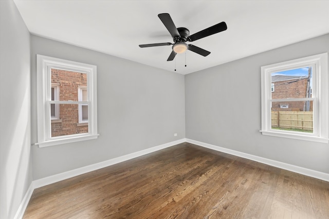 empty room with ceiling fan and dark hardwood / wood-style flooring