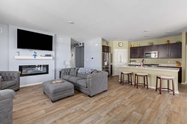 living room featuring light hardwood / wood-style floors and sink