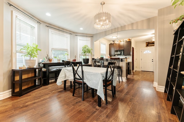 dining area with dark hardwood / wood-style flooring and an inviting chandelier