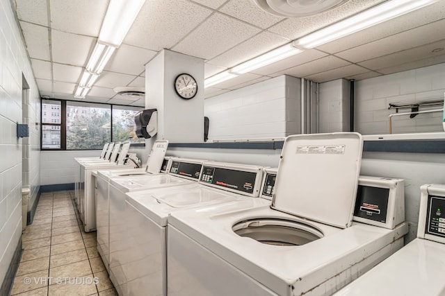 laundry room featuring washing machine and clothes dryer and light tile patterned flooring