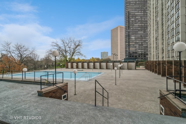 view of pool with area for grilling and a patio