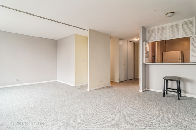 unfurnished living room with light colored carpet