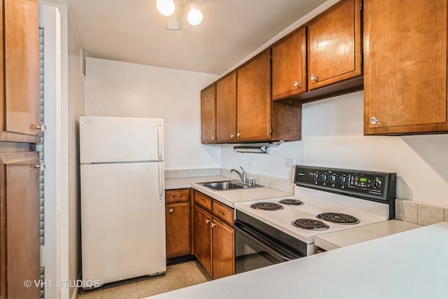 kitchen with white appliances, sink, and light tile patterned floors