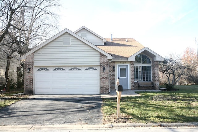 view of front of home with a front yard and a garage