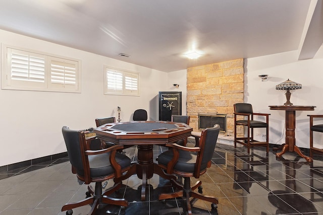 dining area with a fireplace and dark tile patterned floors