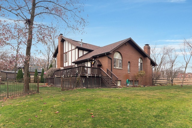 rear view of property featuring a yard and a deck