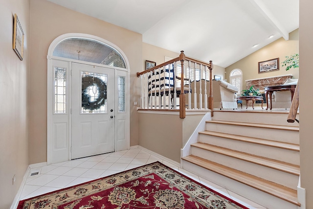 foyer with light tile patterned floors, plenty of natural light, and lofted ceiling