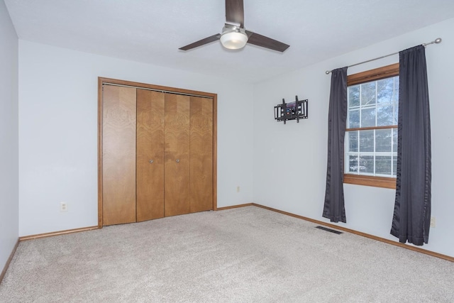 unfurnished bedroom with light colored carpet, ceiling fan, and a closet