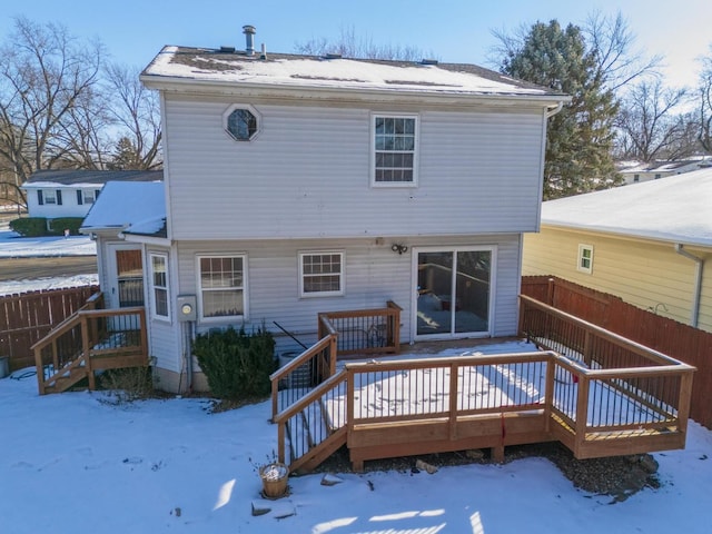 snow covered house with a deck