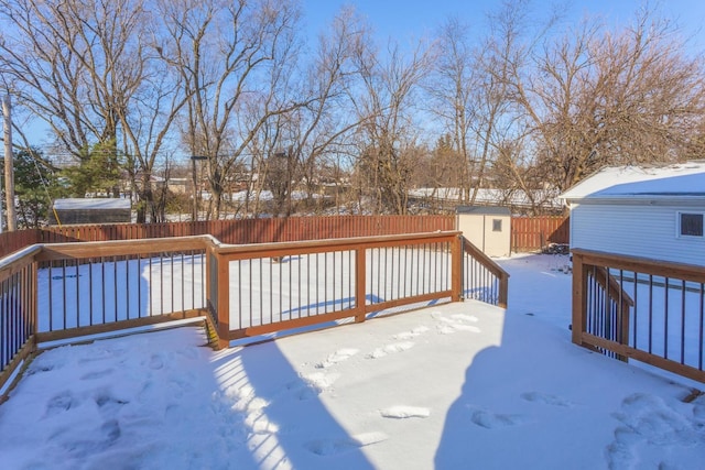 snow covered deck with a shed