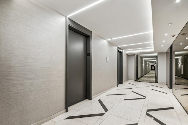 hall with light tile patterned floors and elevator