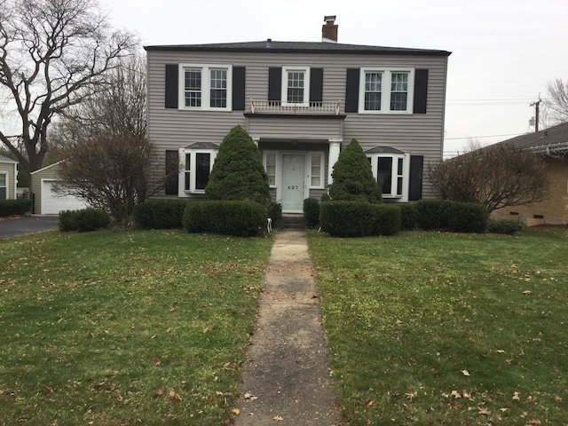 view of front of house with a balcony and a front yard