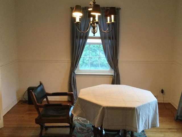 dining space featuring wood-type flooring and an inviting chandelier