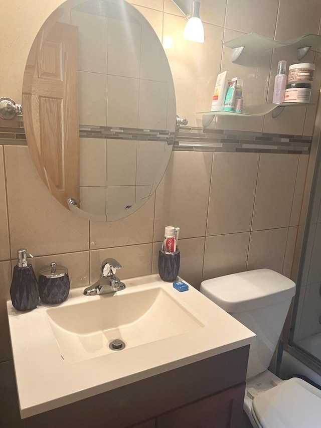 bathroom featuring vanity, toilet, tile walls, and tasteful backsplash