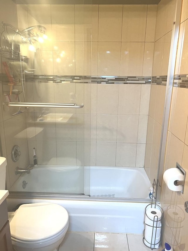 full bathroom with vanity, bath / shower combo with glass door, and toilet