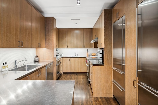 kitchen with backsplash, premium appliances, sink, and dark wood-type flooring