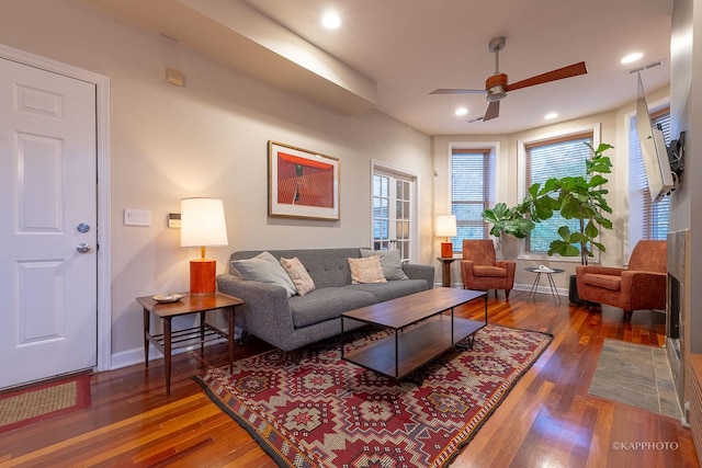 living room featuring plenty of natural light, ceiling fan, and dark wood-type flooring