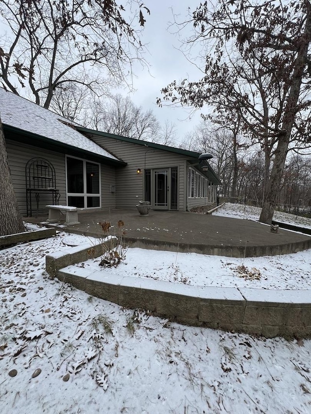 view of snow covered rear of property