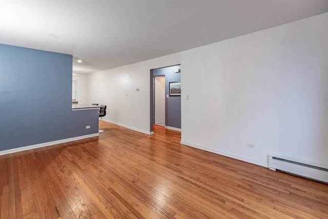 spare room with a baseboard radiator and light wood-type flooring