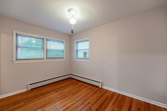 unfurnished room featuring a baseboard radiator and light wood-type flooring