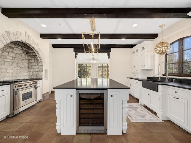 kitchen featuring a notable chandelier, white cabinetry, hanging light fixtures, high end stove, and beverage cooler