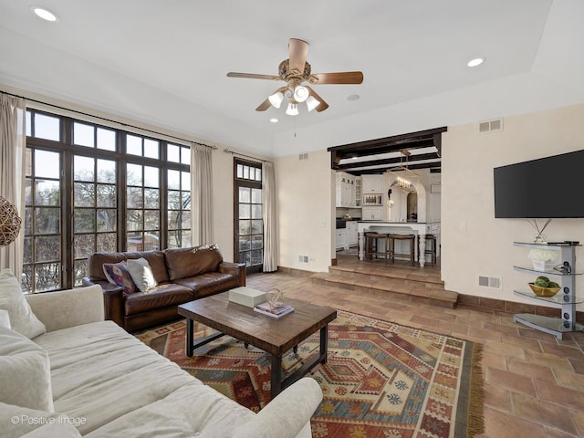 living room featuring ceiling fan and beam ceiling