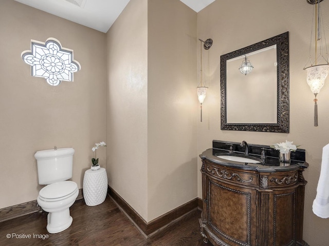 bathroom featuring wood-type flooring, toilet, and vanity