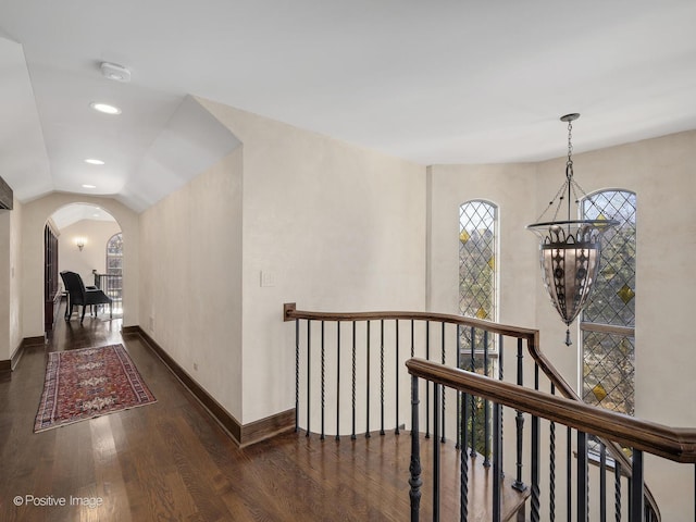 hallway featuring a notable chandelier and dark wood-type flooring