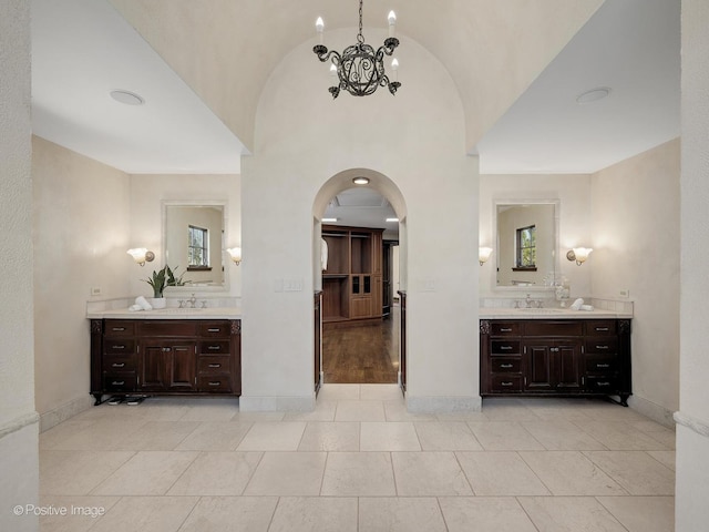 bathroom featuring vanity, vaulted ceiling, and a chandelier