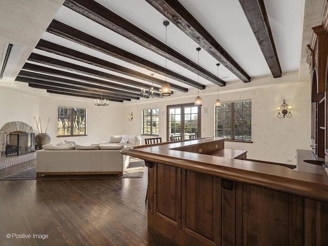 kitchen featuring dark brown cabinets, hanging light fixtures, dark wood-type flooring, a notable chandelier, and beamed ceiling